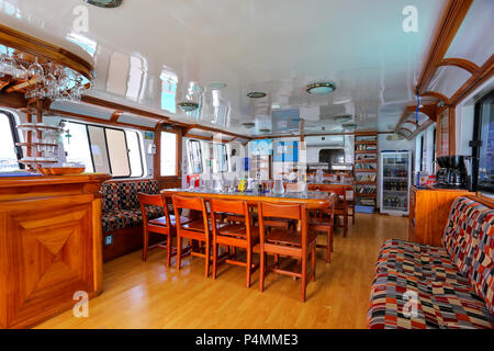 Typical lounge area inside tourist yacht in Galapagos National Park, Ecuador. Tourist yachts are the main way to see islands of the park. Stock Photo