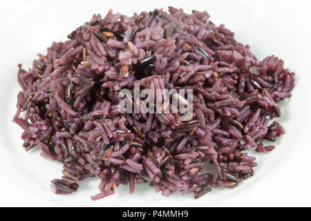 Organic cooked rice black rice, berry rice or black jasmine rice on white background, in hearty concept. Stock Photo