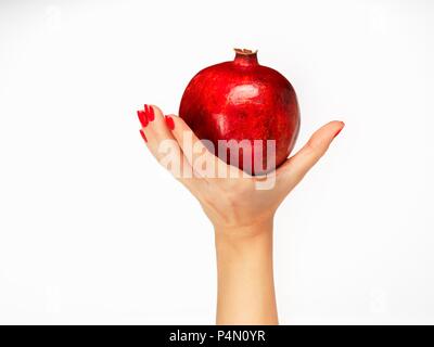 A woman's hand holding a pomegranate Stock Photo