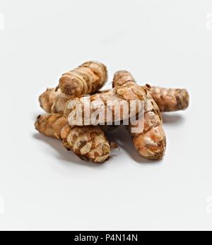 Whole Turmeric Roots on a White Background Stock Photo