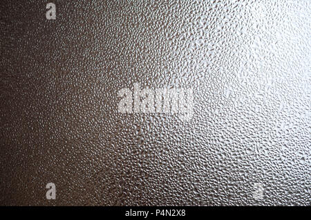 A photo of the glass surface of the window, covered with a multitude of droplets of various sizes. Background texture of a dense layer of condensate o Stock Photo