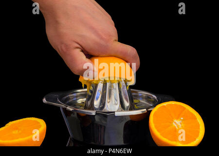 Female hand squeezing orange juice from fresh oranges with a juicer in the  home kitchen, ?lose up Stock Photo - Alamy