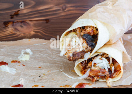 Pulled Pork Wraps with hot BBQ sauce on a wooden tabel Stock Photo