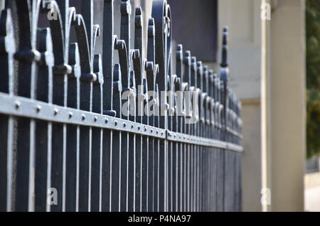 Photo of a decorative metal fence from the cemetery. Selective focus and shallow depth of field . Stock Photo