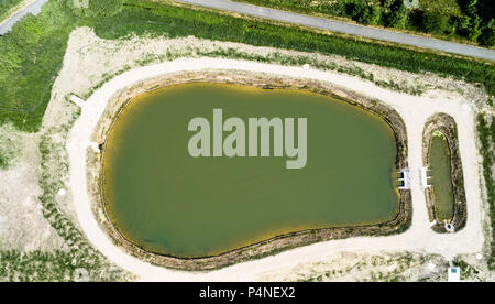 Aerial view of a rain retention basin at the edge of a new development, taken vertically, Germany Stock Photo