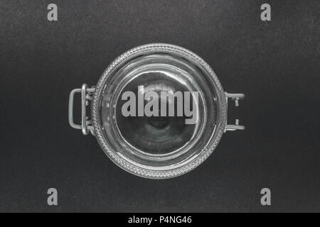 View from top of closed glass jar with metal holder on black background surface Stock Photo