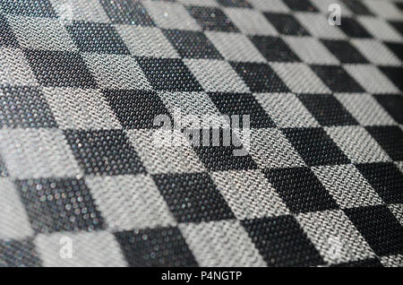 Plastic texture in the form of a very small cloth binding, painted in black and gray in the style of a chessboard. Macro shot . Stock Photo