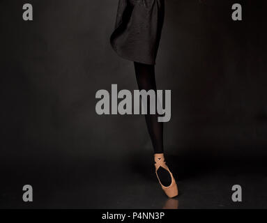 Close up legs of ballerina dancer in studio on dark background Stock Photo