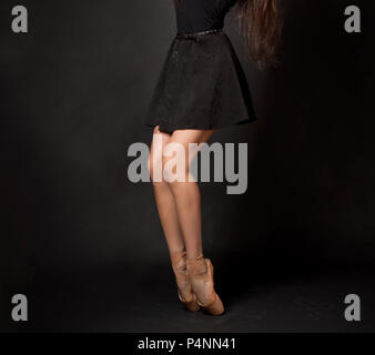 Close up legs of ballerina dancer in studio on dark background Stock Photo