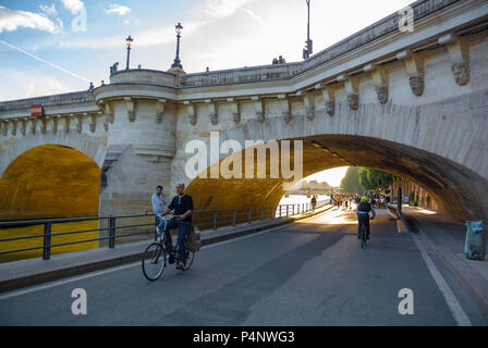 Caucasian Man riding on bicycle through Pont neuf bridge, Paris, IDF, France Stock Photo