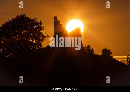 Tutbury, Staffordshire, UK. 22nd June 2018. The sun sets directly behind the Folly at Tutbury Castle, Staffordshire, on the evening of 22nd June 2018. The sun is only directly behind this ruin during a few days of the year, either side of the Summer Solstice. Tutbury Castle was once home to Mary Queen of Scots, and belongs to the Duchy of Lancaster. Credit: Richard Holmes/Alamy Live News Stock Photo