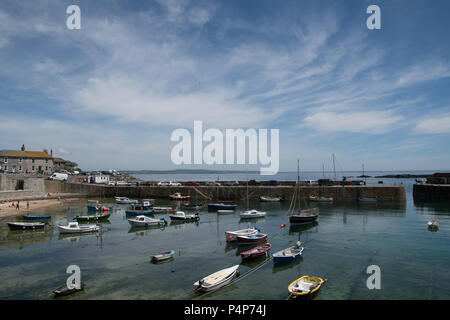 Mousehole, Cornwall, UK. 23rd June 2018. UK Weather. Away from the bustle of the main beaches, familes enjoyed a peaceful sunny afternoon in the harbour at Mousehole. Credit: Simon Maycock/Alamy Live News Stock Photo