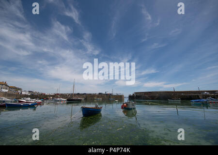 Mousehole, Cornwall, UK. 23rd June 2018. UK Weather. Away from the bustle of the main beaches, familes enjoyed a peaceful sunny afternoon in the harbour at Mousehole. Credit: Simon Maycock/Alamy Live News Stock Photo