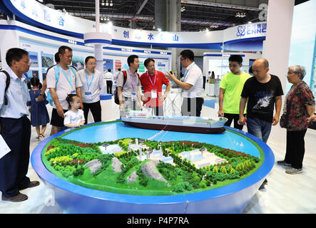 Chongqing, China. 23rd June, 2018. An exhibitor (4th R) introduces his company's clean energy project to visitors at an exhibition held in southwest China's Chongqing Municipality, June 23, 2018. The 9th China International Exhibition of Military and Civil Technologies kicked off Thursday in southwest China's Chongqing Municipality, drawing more than 200 delegations from China and abroad. The number of visitors to the exhibition peaked Saturday. Credit: Wang Quanchao/Xinhua/Alamy Live News Stock Photo