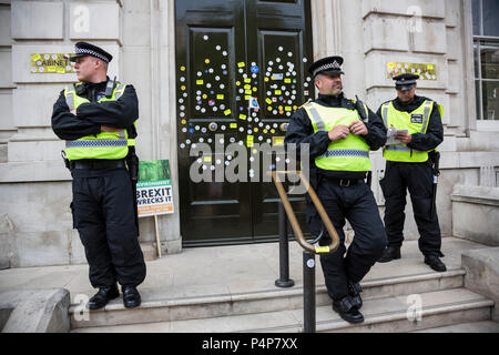 London, UK. 23 June 2018. Police officers guard the front door of the Cabinet Office from more defacement with stickers from remain supporters and protesters at an Anti-Brexit march and rally for the People's Vote. Photo: Bettina Strenske/Alamy Live News