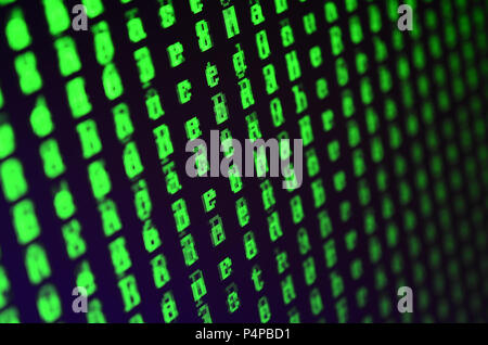Macro shot of a glitch on the monitor of an office computer. The concept of introducing a virus into a personal data keeper. Stream of random green sy Stock Photo