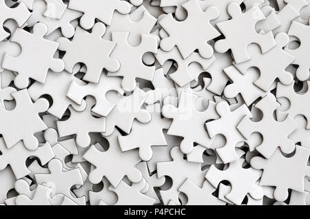 Close-up of a pile of uncompleted elements of a white puzzle. A huge number of rectangular pieces from one large white mosaic Stock Photo