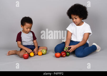 Young cute African siblings together against gray background Stock Photo