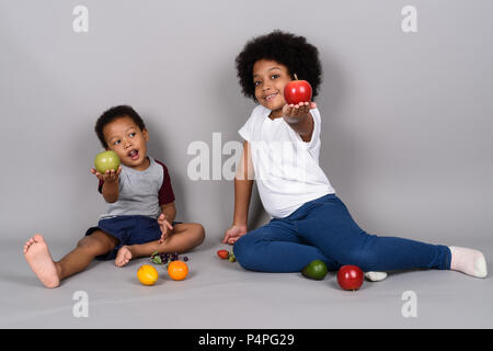 Young cute African siblings together against gray background Stock Photo