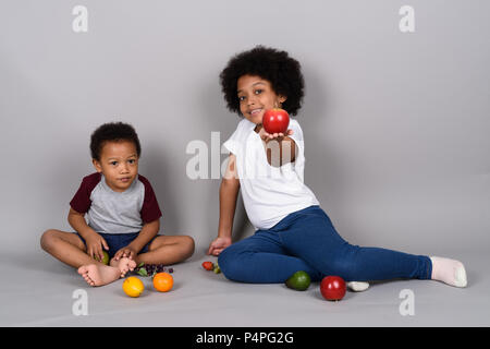 Young cute African siblings together against gray background Stock Photo