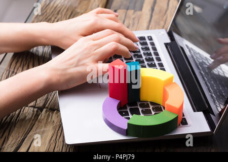 Businesswoman Using Laptop With Multi Colored 3d Pie Chart Stock Photo