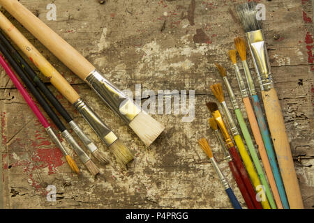 different size paint brushes on a rustic wood table, artist workshop Stock Photo