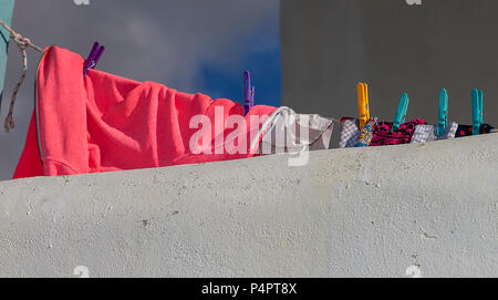 Colourful clothes drying outdoors on a balcony. Stock Image. Stock Photo