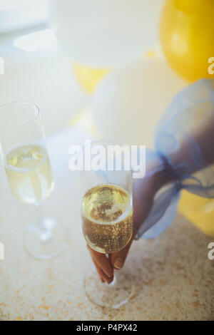 Pouring champagne in flutes standing on table Close up Stock Photo