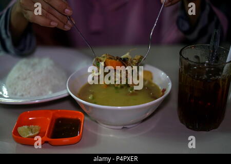 Delicious Nasi Soto, the Traditional Indonesian Food Served with Rice and Ice Tea Stock Photo