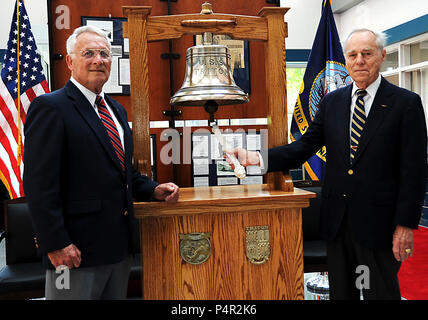 GREAT LAKES, Ill. (May 17, 2012) Retired Master Chief Harold Weston, former nuclear-powered radar picket submarine USS Triton (SSN-586) chief of the boat, stands by as Retired Capt. Robert Rawlings, former USS Triton (SSN-586) commanding officer, tolls the bell for his last time on the quarterdeck of the USS Triton recruit barracks at Recruit Training Command (RTC), after a ship's bell dedication ceremony here May 17. The ceremony honored those who served aboard the Tambor-class submarine USS Triton (SS-201) and the USS Triton (SSN-586). The bell, which was previously lost for 43 years, has no Stock Photo