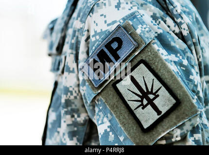 NAVAL STATION GUANTANAMO BAY, Cuba (Sept. 13, 2011) – The unit patch of the 107th Military Police Company, from Utica NY, merges the crown from the Statue of Liberty and a sword and is prominently displayed on the left arm of a soldier assigned to the company. The 107th MP CO provides external security to JTF Guantanamo and fall under the leadership of the 525th Military Police Battalion. JTF Guantanamo provides safe, humane, legal and transparent care and custody of detainees, including those convicted by military commission and those ordered released by a court. The JTF conducts intelligence Stock Photo