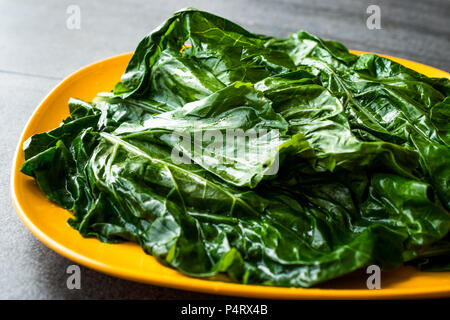 Black Cabbage Leaves / Organic Green Lacinato Kale on Yellow Plate with Grey Granit Surface. Organic Food. Stock Photo