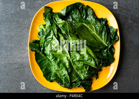 Black Cabbage Leaves / Organic Green Lacinato Kale on Yellow Plate with Grey Granit Surface. Organic Food.