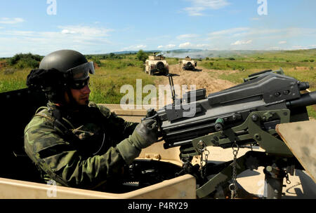 A member of the Slovak Republic 5th Special Forces Regiment conducts security with a U.S. 50-caliber heavy machine gun inside a HUMMV as other members of his team position their vehicles to do the same at the Military Training Center in Slovakia as part of a Partnership Development Program event. Stock Photo