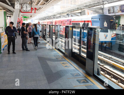 Passengers waiting near safety barrier at subway (BTS) station, Bangkok, Thailand, Asia. Stock Photo