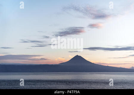 View from the Azores island Sao Jorge to the island Pico with the volcano 'Ponta do Pico', the highest mountain of Portugal, in the evening light with Stock Photo