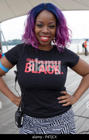 Posed portrait of a security guard at a rally wearing a tee shirt that says UNAPOLOGETICALLY BLACK. In Greenwich Village in New York City. Stock Photo