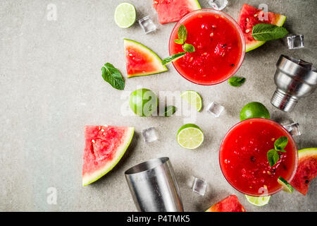 Watermelon margarita cocktail with lime and sliced watermelon, light concrete background copy space Stock Photo