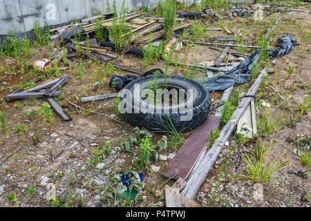 Environment. The tire of the car and debris dumped on the ground Stock Photo