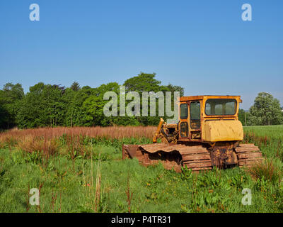 An Old Bulldozer in a Farm Field near Letham in Angus, Scotland, Its yellow Cabin rusted with age. Going nowhere.