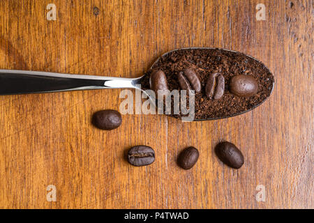 Ground coffee beans on metal spoon Stock Photo