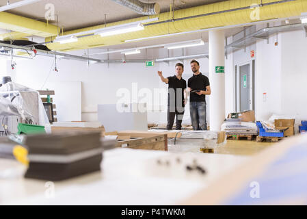 Two men talking in factory Stock Photo