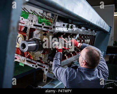 Worker in factory repairing engine block Stock Photo
