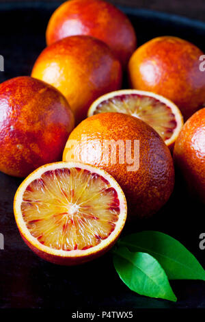 Whole and sliced blood oranges, close-up Stock Photo