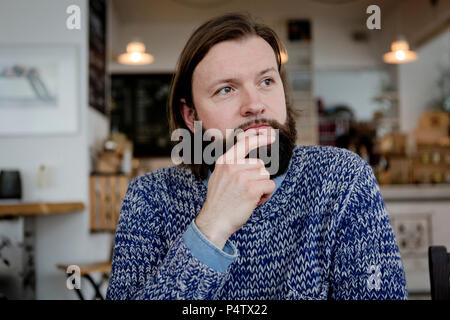Man with beard sitting in cafe, portrait Stock Photo