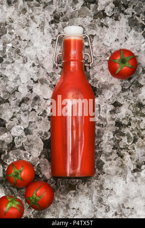 Ice-cooled homemade tomato juice in swing top bottle Stock Photo