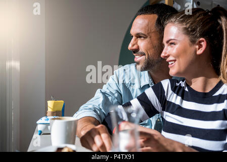 Happy couple in a cafe looking out of window Stock Photo