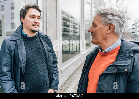 Young man and senior man talking in the city Stock Photo