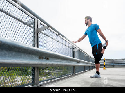 Man stetching on a parking level Stock Photo