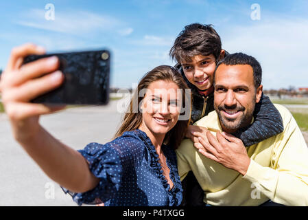 Happy family taking a selfie outdoors Stock Photo